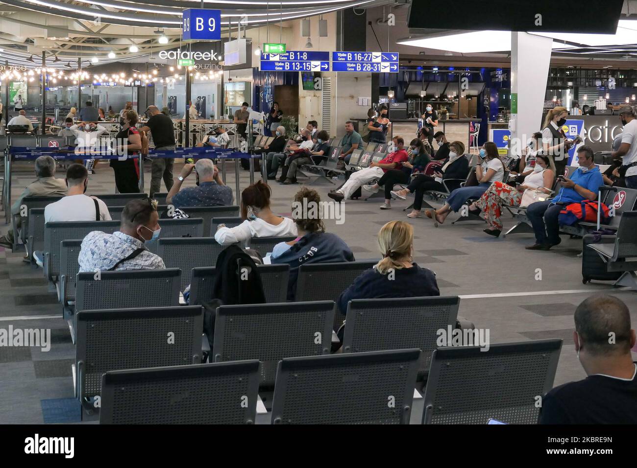 Passeggeri visti con le maschere facciali obbligatorie all'aeroporto internazionale ATH LGAV di Atene, in Grecia, il 18 giugno 2020, dopo la quarantena di Coronavirus e le restrizioni di viaggio. I passeggeri che indossano maschere e guanti, utilizzano disinfettanti per le mani come misura preventiva contro la diffusione della pandemia COVID-19. La Grecia e l'Europa hanno chiuso a lungo le frontiere per le persone al di fuori dell'Europa e della zona Schengen, ma la Grecia ha iniziato a revocare il divieto di circolazione dal 15 giugno 2020 per i paesi della zona Schengen e il 1 luglio 2020 si arriverà a un maggiore allentamento. I passeggeri in arrivo sono soggetti al decor Foto Stock