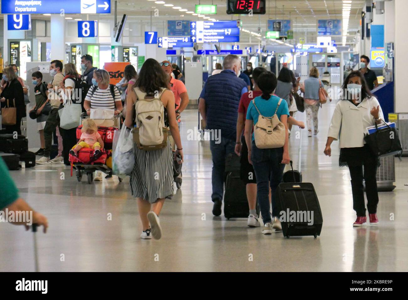 Passeggeri visti con le maschere facciali obbligatorie all'aeroporto internazionale ATH LGAV di Atene, in Grecia, il 18 giugno 2020, dopo la quarantena di Coronavirus e le restrizioni di viaggio. I passeggeri che indossano maschere e guanti, utilizzano disinfettanti per le mani come misura preventiva contro la diffusione della pandemia COVID-19. La Grecia e l'Europa hanno chiuso a lungo le frontiere per le persone al di fuori dell'Europa e della zona Schengen, ma la Grecia ha iniziato a revocare il divieto di circolazione dal 15 giugno 2020 per i paesi della zona Schengen e il 1 luglio 2020 si arriverà a un maggiore allentamento. I passeggeri in arrivo sono soggetti al decor Foto Stock