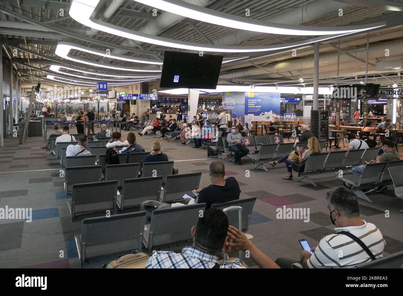 Passeggeri visti con le maschere facciali obbligatorie all'aeroporto internazionale ATH LGAV di Atene, in Grecia, il 18 giugno 2020, dopo la quarantena di Coronavirus e le restrizioni di viaggio. I passeggeri che indossano maschere e guanti, utilizzano disinfettanti per le mani come misura preventiva contro la diffusione della pandemia COVID-19. La Grecia e l'Europa hanno chiuso a lungo le frontiere per le persone al di fuori dell'Europa e della zona Schengen, ma la Grecia ha iniziato a revocare il divieto di circolazione dal 15 giugno 2020 per i paesi della zona Schengen e il 1 luglio 2020 si arriverà a un maggiore allentamento. I passeggeri in arrivo sono soggetti al decor Foto Stock