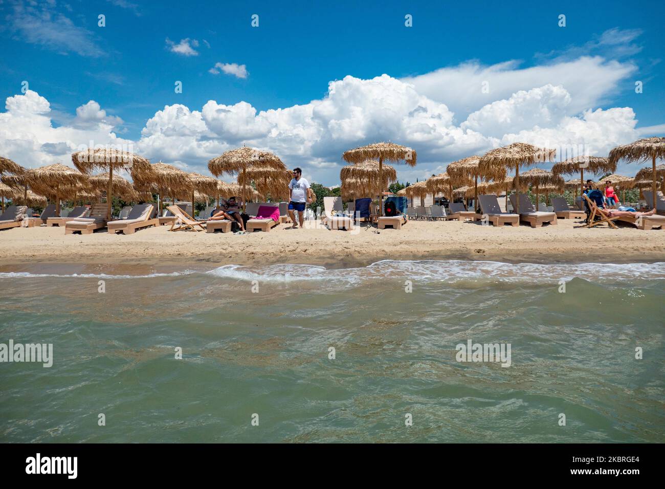 Spiaggia di sabbia durante una giornata di sole e Beach Bar a Nea Irakleia, Chalkidiki in Grecia, con i primi beachgoer in arrivo per nuotare e prendere il sole. Halkidiki è famosa per la sabbia dorata, le acque cristalline e trasparenti e il facile accesso alle spiagge. Beachbars, alberghi e spiagge organizzate hanno aperto in Grecia come Covid-19 Coronavirus pandemic misure di blocco revocato in Grecia e l'industria del turismo è pronta per il rilancio dal giugno 15, aprendo le frontiere e ricevendo turisti. Giugno 22, 2020 (Foto di Nicolas Economou/NurPhoto) Foto Stock