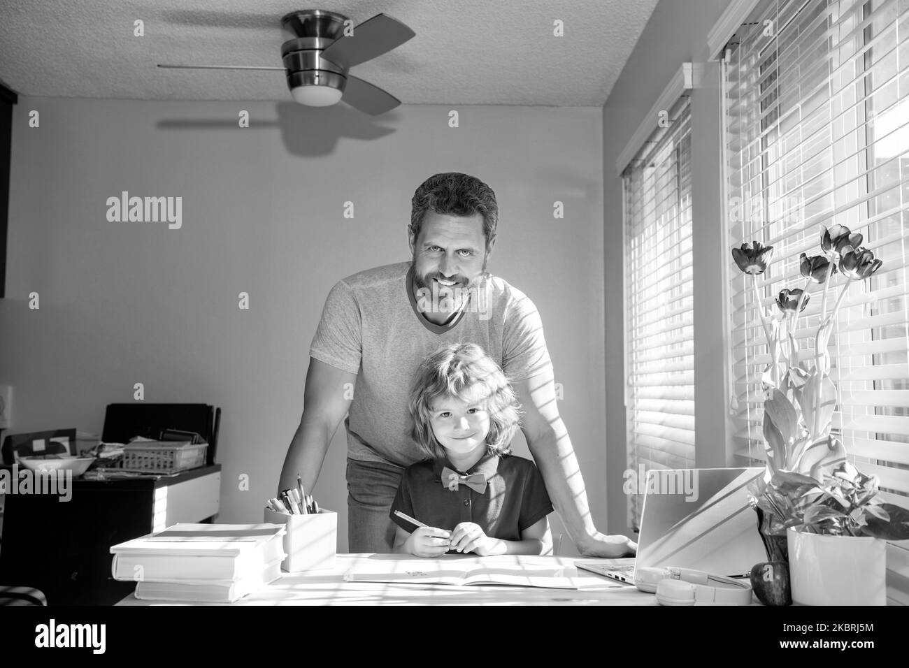 allegro papà scrittura scuola compiti con suo figlio in classe, paternità Foto Stock