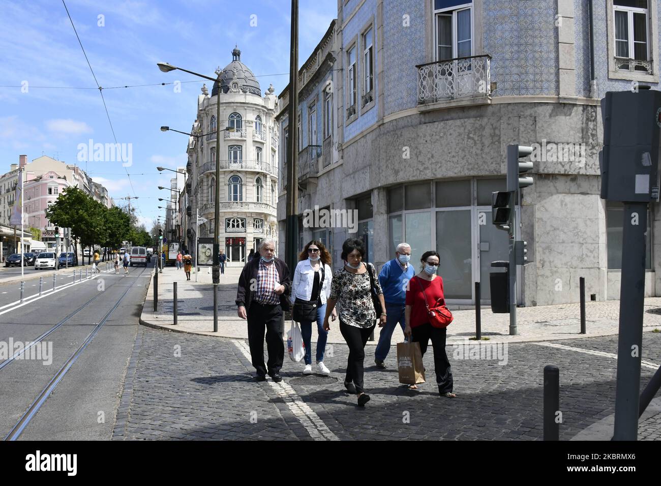 Persone che indossano maschere protettive camminano attraverso un quartiere di Lisbona, 26 giugno 2020. Il Portogallo apre la stagione estiva con tre fasi: Allarme, emergenza e ritiro per prevenire la diffusione del COVID-19, che continua ad espandersi nell'area metropolitana di Lisbona, dove la maggior parte del contagio è concentrata. (Foto di Jorge Mantilla/NurPhoto) Foto Stock