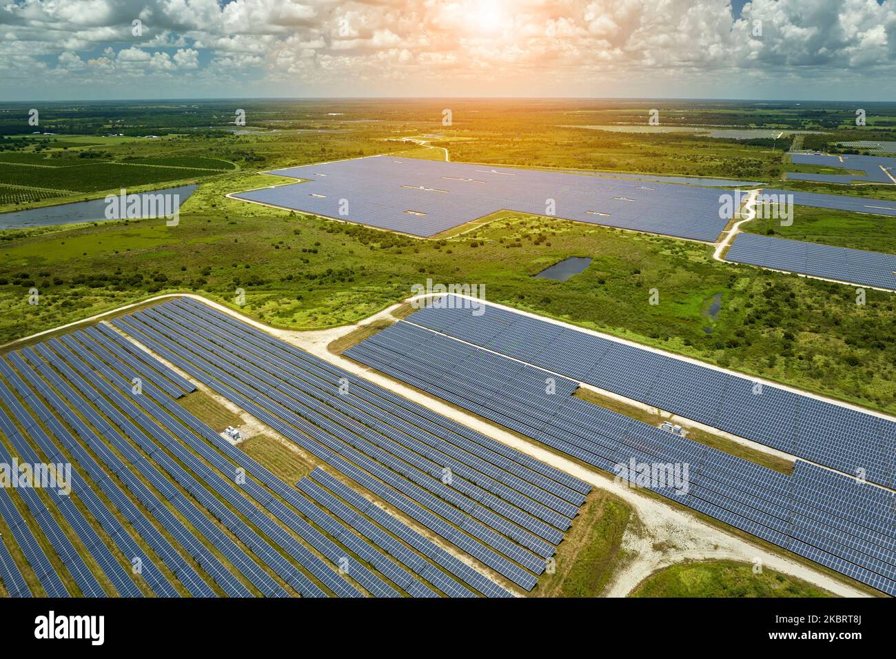 Vista aerea di una grande centrale elettrica sostenibile con molte file di pannelli solari fotovoltaici per la produzione di energia elettrica pulita. Rinnovabile Foto Stock