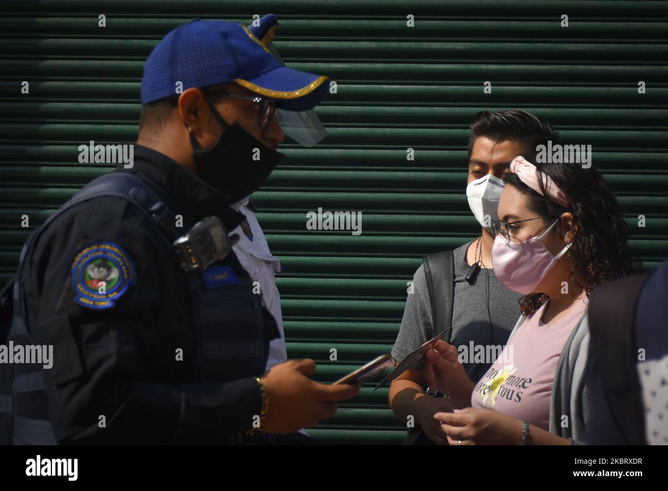 Un poliziotto controlla il pass di ingresso di un lavoratore su Madero Street il 30 giugno 2020 a Città del Messico, Messico. Città del Messico ha iniziato la graduale riapertura di alcune attività commerciali con giorni di lavoro scaglionati al 30% della loro capacità e con un calendario dalle 11am alle 5 per evitare spazi affollati. Anche tutte le stazioni della metropolitana sono state riaperte. (Foto di Guillermo GutiÃ©rrez/NurPhoto) Foto Stock