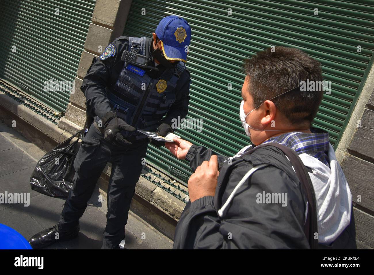Un poliziotto controlla il pass di ingresso di un lavoratore il 30 giugno 2020 a Città del Messico, Messico. Città del Messico ha iniziato la graduale riapertura di alcune attività commerciali con giorni di lavoro scaglionati al 30% della loro capacità e con un calendario dalle 11am alle 5 per evitare spazi affollati. Anche tutte le stazioni della metropolitana sono state riaperte. (Foto di Guillermo GutiÃ©rrez/NurPhoto) Foto Stock