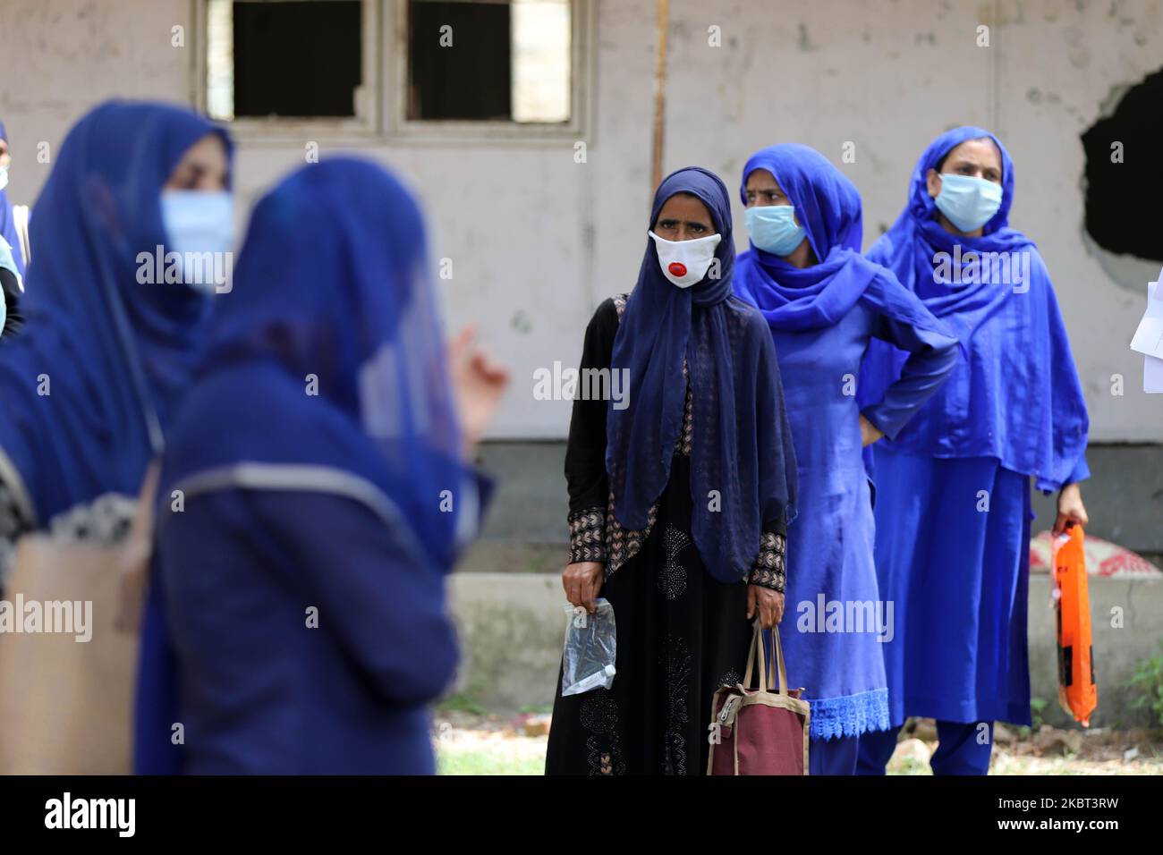 La gente attende in coda durante i test COVID-19 (coronavirus) nel distretto di Baramulla, Jammu e Kashmir, India, il 04 luglio 2020. Un team di esperti guidati dal medico di blocco Boniyar Dr. Pervaiz Masoodi, ha condotto test casuali nella zona sui gradini di accesso della gente. Le persone sono state informate in anticipo dal reparto di collaborare con il team medico e venire avanti per i test per la loro sicurezza. I lavoratori di Asha e altri medici di Boniyar Block hanno lavorato sodo per convincere le persone a un campionamento casuale. In occasione BMO Boniyar ha detto che hanno un obiettivo di 2 campioni oggi mentre un Foto Stock