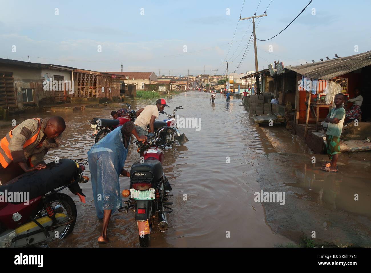 I motociclisti commerciali, conosciuti come i motociclisti di okada, arrestano il lavoro mentre l'alluvione prende sopra IgE Road, Aboru, Lagos. Alluvione sconvolse il movimento e le attività socio-economiche nella zona di Alabede di IgE Road, Aboru, Lagos, Nigeria dopo un pesante calo il 6 luglio 2020. (Foto di Adekunle Ajayi/NurPhoto) Foto Stock