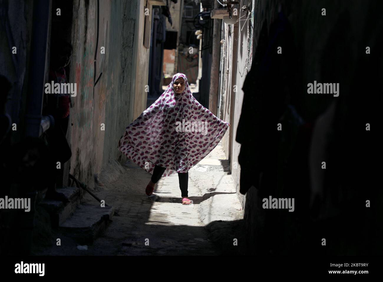 Una ragazza palestinese cammina fuori dalla casa della sua famiglia nel campo di al-Shati per i rifugiati palestinesi nella striscia di Gaza occidentale il 9 luglio 2020. (Foto di Majdi Fathi/NurPhoto) Foto Stock