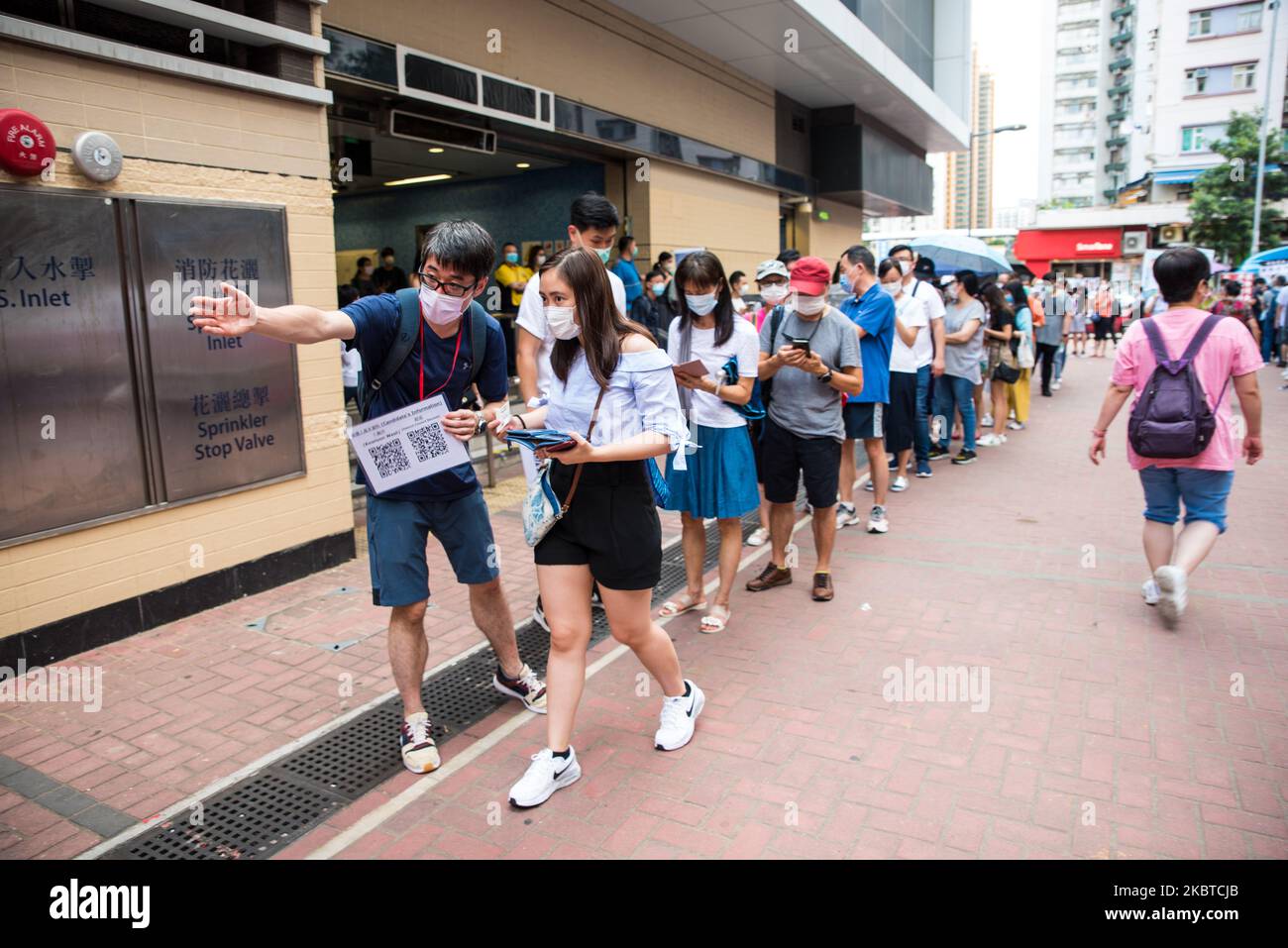Un volontario dice ad un elettore che è il suo turno di andare a votare per le primarie pandemocratiche a Whampoa a Hong Kong, Cina, il 11 luglio 2020. Il governo di Hong Kong li ha denunciati come una ''violazione'' della legge sulla sicurezza nazionale, e la polizia ha fatto irruzione negli uffici dell'impresa che organizzava la votazione la sera precedente la votazione, ritardando così l'inizio alle 12,00. (Foto di Marc Fernandes/NurPhoto) Foto Stock