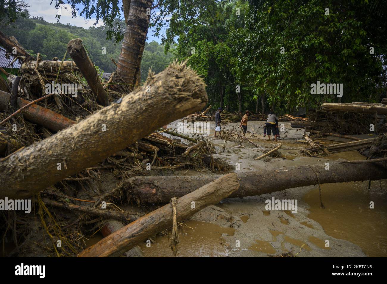 I residenti sono stati evacuati attraverso un mucchio di legno e fango da case fangose a causa di essere stati colpiti da inondazioni flash nel villaggio di Oloboju, Sigi Regency, a circa 20 chilometri da Palu City, la capitale della provincia di Sulawesi Centrale, Indonesia il 11 luglio 2020. Alluvioni flash che si sono verificate il 10 luglio 2020, notte a causa di forti piogge che trasportano fango e materiali in legno. Le alluvioni improvvise che spesso si verificano nella zona hanno spazzato le case dei residenti e lavato via capre e bestiame e distrutto centinaia di ettari di terreno agricolo di proprietà dei residenti. Questa inondazione flash è l'ennesima volta che è accaduto nel Foto Stock