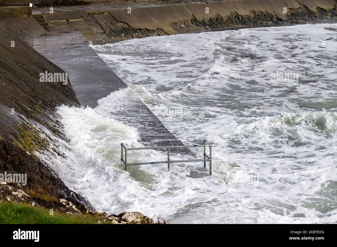 Tempesta ondate di picco che rompono le difese del mare. Tragumna, West Cork, Irlanda Foto Stock