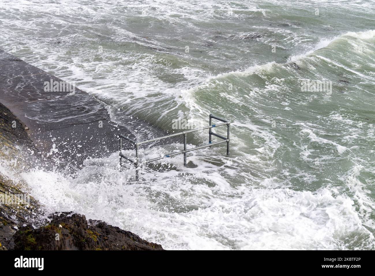 Tempesta ondate di picco che rompono le difese del mare. Tragumna, West Cork, Irlanda Foto Stock