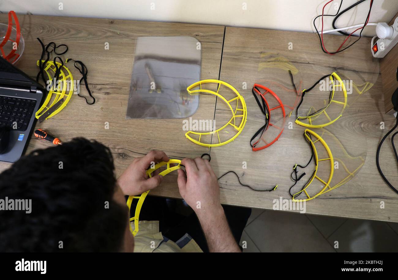 Un membro dello staff assembla uno schermo facciale stampato del 3D realizzato nell'ambito del progetto Glia, che produce forniture mediche a basso costo per le regioni povere, durante la pandemia COVID-19 in corso a Gaza City il 13 luglio 2020. (Foto di Majdi Fathi/NurPhoto) Foto Stock