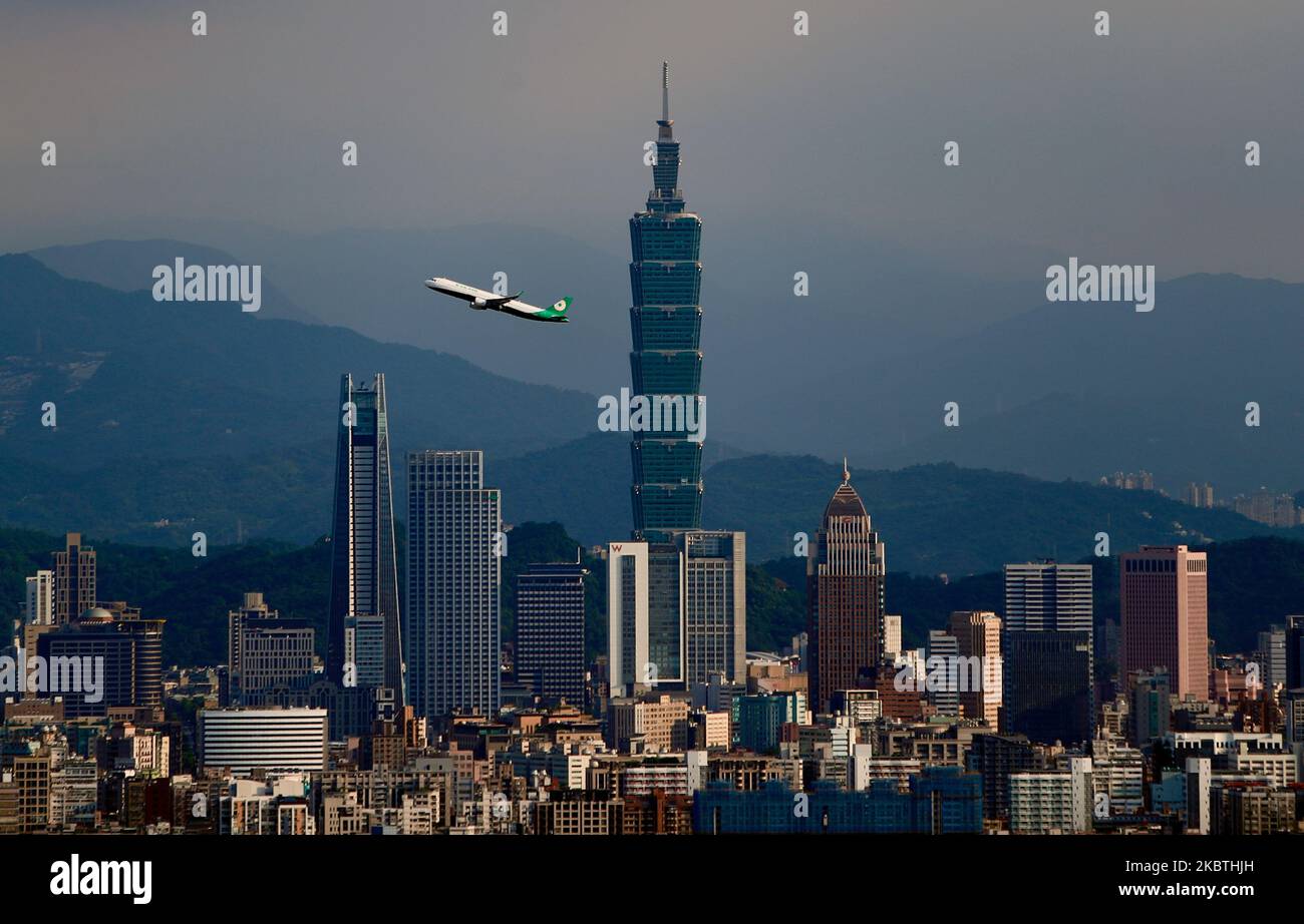 Un volo nazionale che collega Taipei City al Nangan Township parte dall'Aeroporto di Songshan e passa davanti all'edificio Taipei 101, nel mezzo della diffusione della pandemia di Covid-19, Taipei City, Taiwan, 12 luglio 2020.a differenza di altri paesi come l'India e il Regno Unito in cui sono stati effettuati divieti completi e parziali sui voli interni, rispettivamente da quando la pandemia ha cominciato a diffondersi, le compagnie aeree per i viaggiatori nazionali a Taiwan non sono state colpite dal fatto che il governo non ha aumentato la sospensione, Mantenere i viaggi essenziali di tutti i tipi fra le contee dell'isola e all'interno di Taiwan è Foto Stock