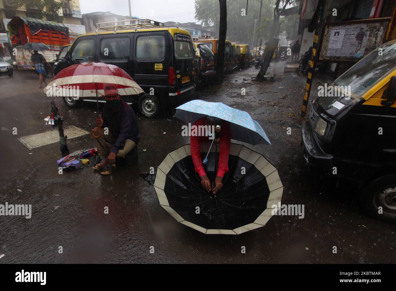 Un uomo ripara un ombrello su una strada durante le forti piogge a Mumbai, in India, il 15 luglio 2020. (Foto di Himanshu Bhatt/NurPhoto) Foto Stock