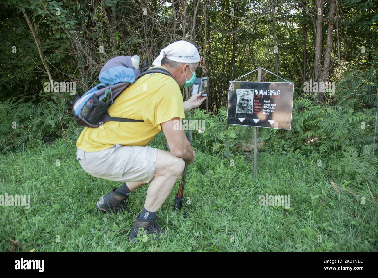 Un partecipante scatta una fotografia di uno dei numerosi segni che indicano la posizione delle tombe di massa trovate dopo la guerra in Bosnia-Erzegovina il 8 luglio 2020. La Marte Mira (marcia della Pace) è una passeggiata che dal 2005 è stata organizzata annualmente tra il 8 e il 10 luglio in memoria delle vittime del genocidio Srebrenica del 1995. Durante i tre giorni in cui si svolge la marcia, i partecipanti camminano su strada e, soprattutto, sulle ripide montagne, la distanza che collega le città di Nezuk e Potocari, dove si trova il cimitero commemorativo del genocidio di Srebrenica. (Foto di Jose Antonio Sanchez/NurPhot Foto Stock