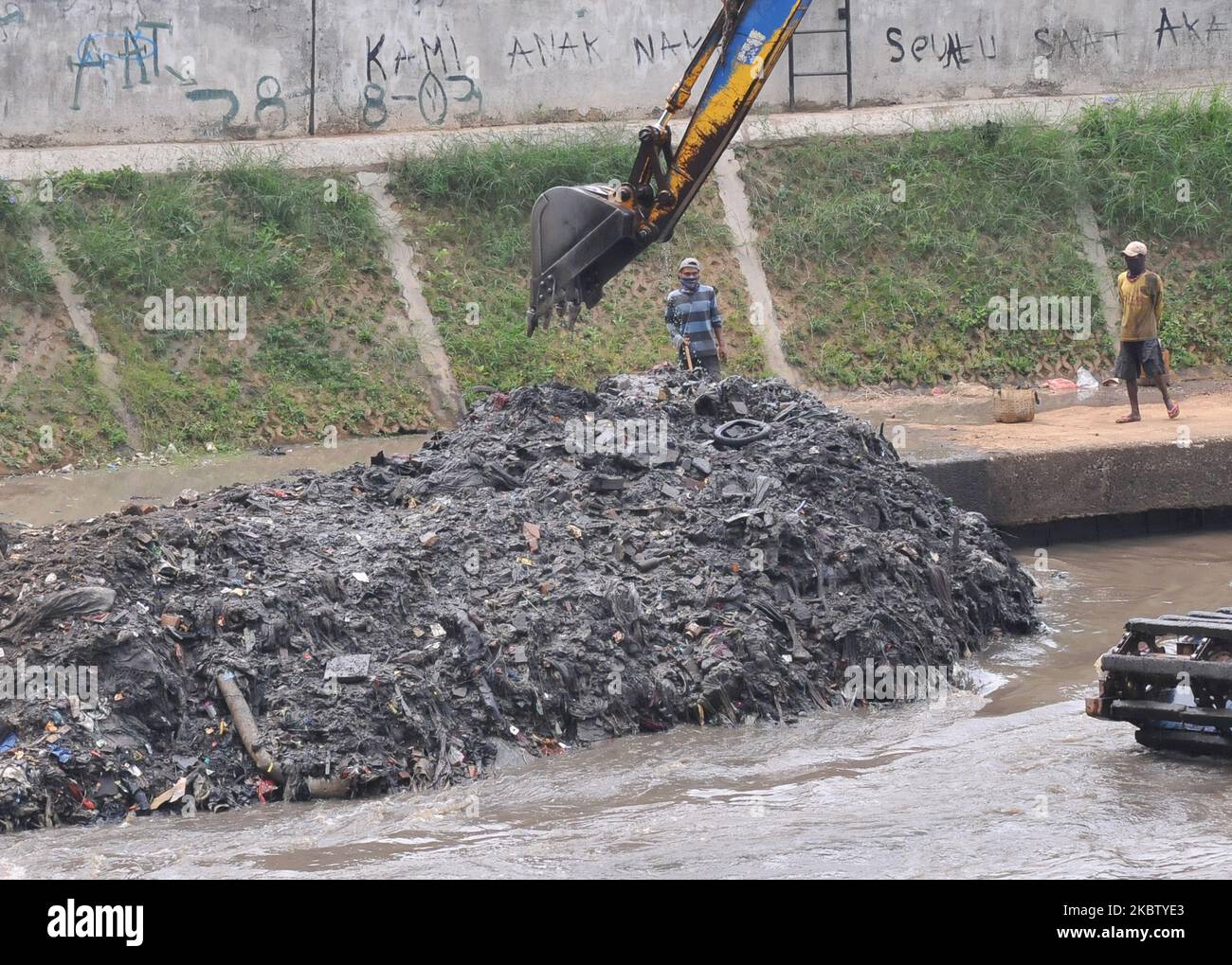 Usando gli operai pesanti dell'attrezzatura dragano il fango contenuto nel fiume di Ciliwung che attraversa i residenti in Jatinegara, Jakarta, il luglio, 20,2020. Il dragaggio del fango è di approfondire i tempi poco profondi per anticipare la possibilità di un aumento nello scarico di acqua durante le piogge pesanti e l'acqua di trasporto. (Foto di Dasril Roszandi/NurPhoto) Foto Stock