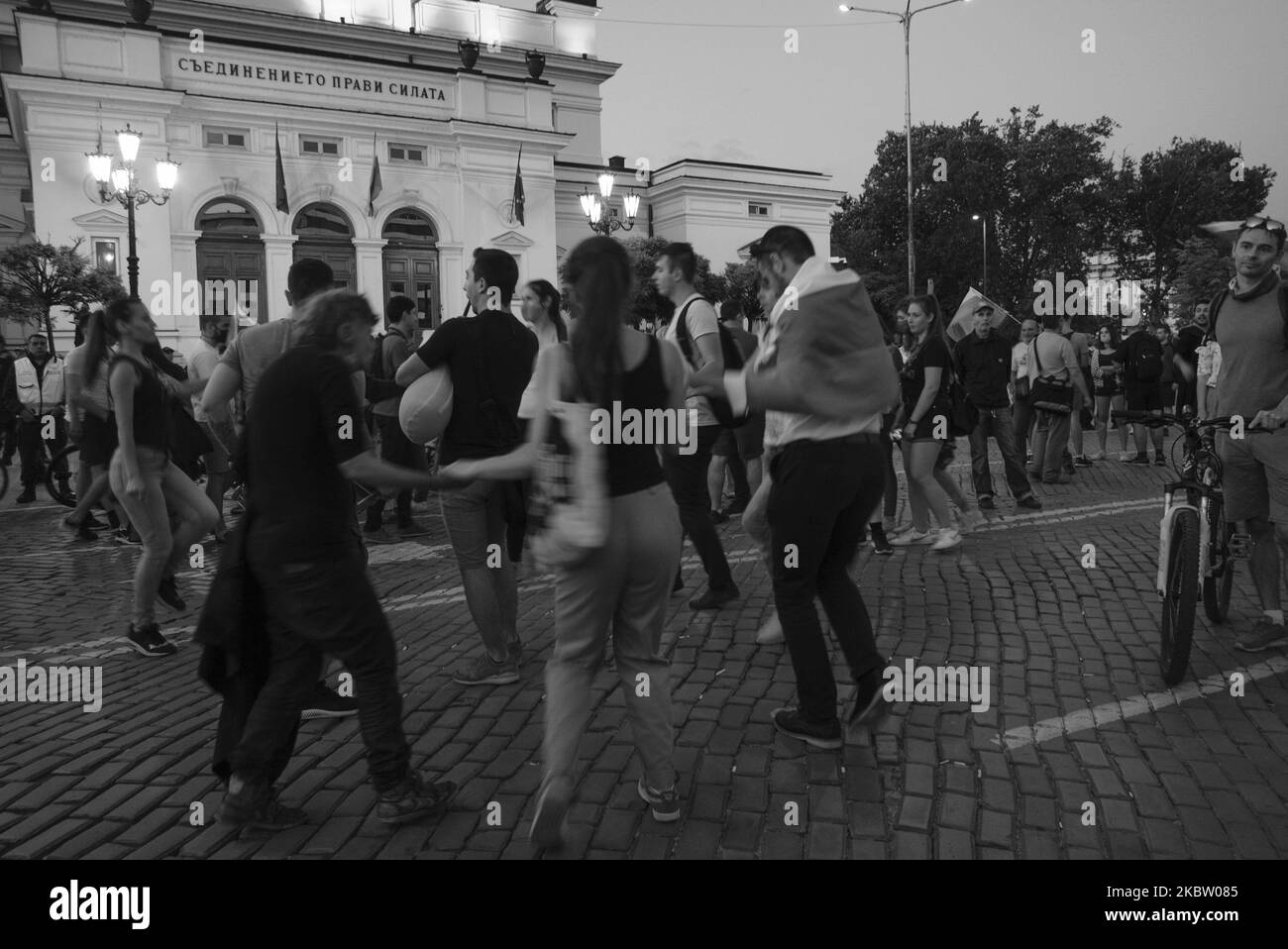 (NOTA DEL REDATTORE: L'immagine è stata convertita in bianco e nero) i manifestanti hanno ballato un horo tradizionale durante le proteste antigovernative a Sofia, in Bulgaria, il 20 luglio 2020. Dopo più di una settimana di proteste quotidiane, il governo ha deciso di tenere un voto di sfiducia la mattina seguente. I manifestanti hanno chiesto le dimissioni del primo ministro Boyko Borisov di lunga data e la fine dell'influenza mafiosa in politica. (Foto di Jodi Hilton/NurPhoto) Foto Stock
