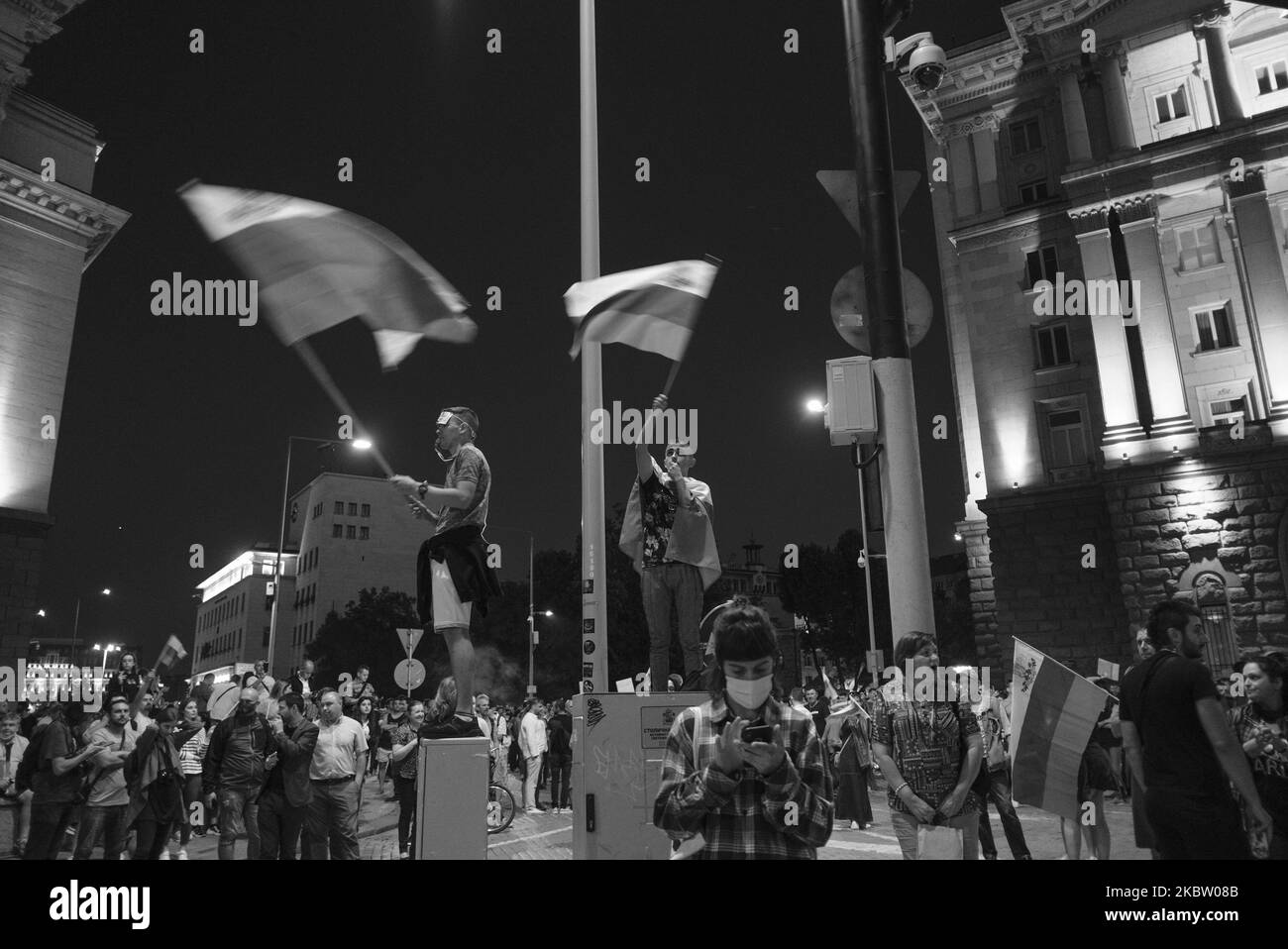 (NOTA DELL'EDITORE: L'immagine è stata convertita in bianco e nero) i ragazzi sventolavano le bandiere mentre le tousands si riunivano per le proteste dell'antigoverno a Sofia, in Bulgaria, il 20 luglio 2020. Dopo più di una settimana di proteste quotidiane, il governo ha deciso di tenere un voto di sfiducia la mattina seguente. I manifestanti hanno chiesto le dimissioni del primo ministro Boyko Borisov di lunga data e la fine dell'influenza mafiosa in politica. (Foto di Jodi Hilton/NurPhoto) Foto Stock