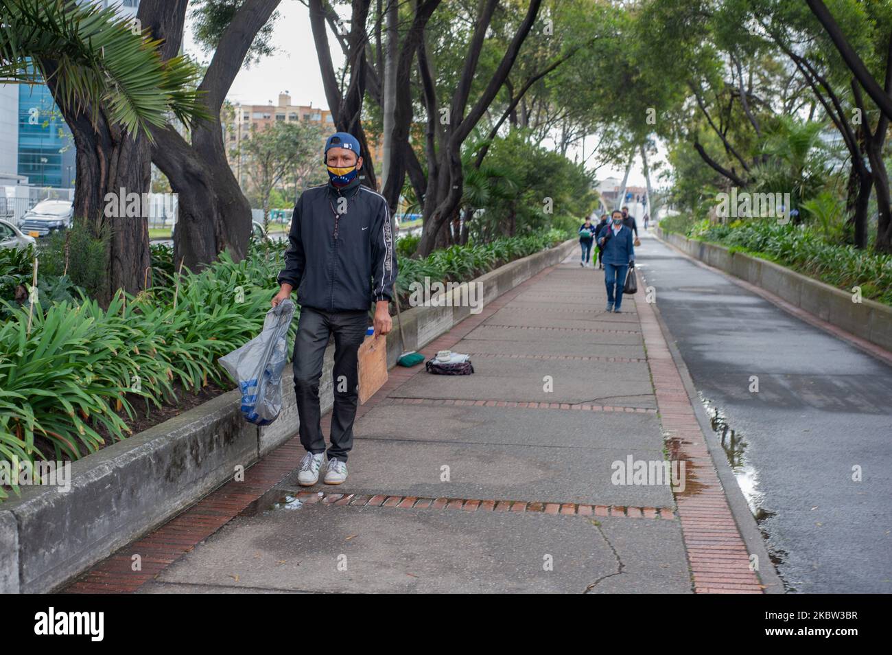 Un immigrato venezuelano ricorda le foglie degli alberi per strada mentre usa una maschera protettiva con la bandiera venezuelana durante i blocchi settorializzati in mezzo alla pandemia di Coronavirus a Bogotà, Colombia, il 22 luglio 2020. (Foto di Sebastian Barros/NurPhoto) Foto Stock