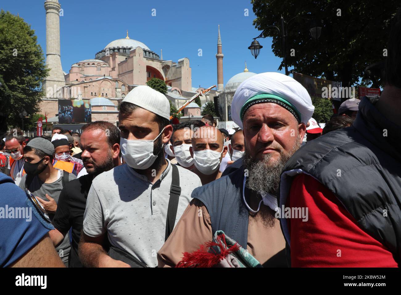 La gente attende la prima preghiera ufficiale del venerdì per iniziare fuori dalla Moschea di Hagia Sophia il 24 luglio 2020 a Istanbul, in Turchia. Il presidente della Turchia Recep Tayyip Erdogan ha partecipato alla prima preghiera del venerdì all'interno della Moschea di Hagia Sophia dopo che è stata ufficialmente riconvertita in una moschea da un museo. La controversa decisione di cambiare lo status degli edifici iconici è avvenuta dopo che la più alta corte amministrativa della Turchia ha votato il 10 luglio per revocare lo status delle strutture come museo, consentendone la conversione in moschea. Nel corso della sua storia, il sito patrimonio dell'umanità dell'UNESCO è stato un gatto bizantino Foto Stock