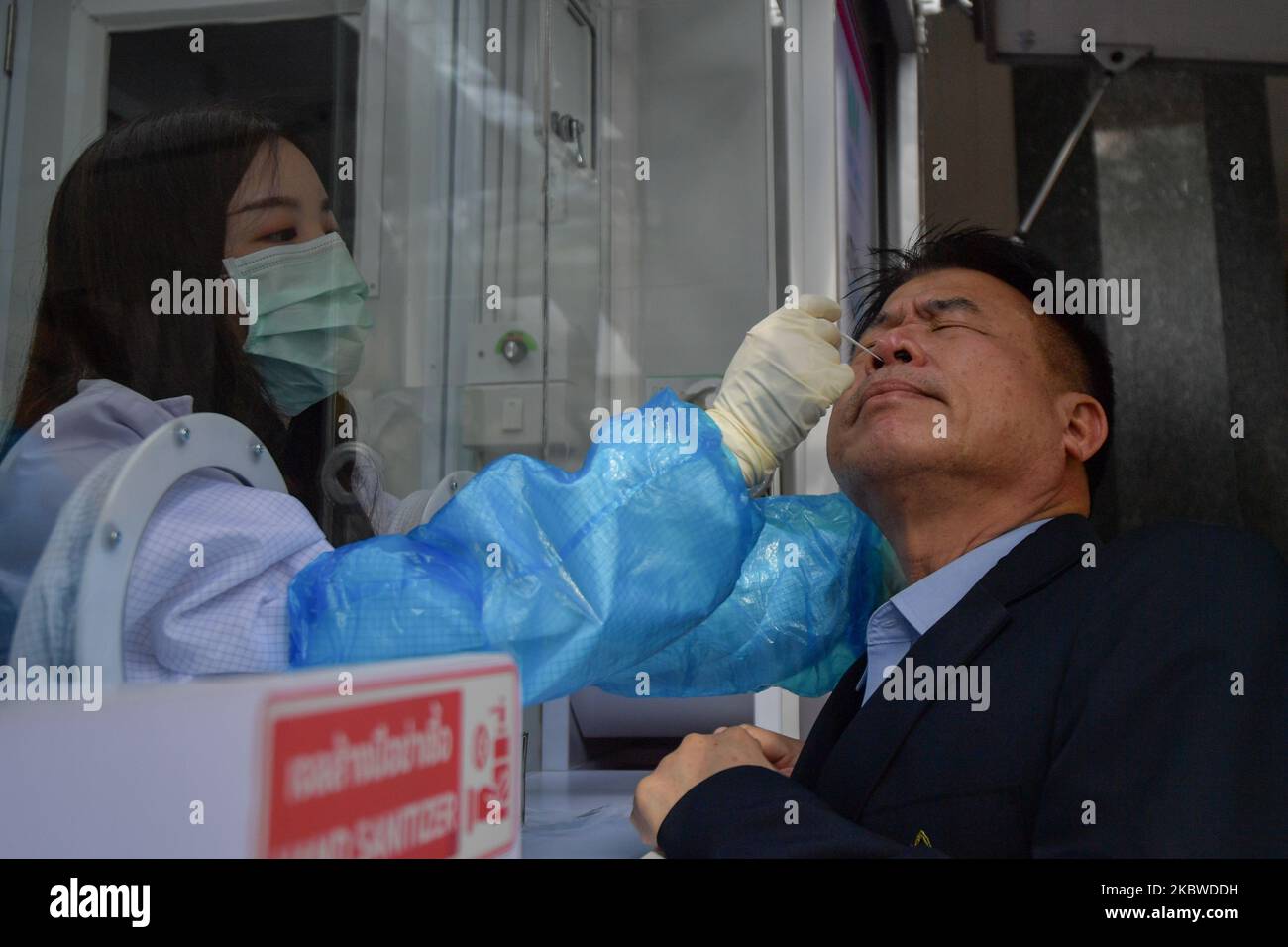 Un operatore sanitario che indossa maschere protettive e guanti esegue il test con tampone nasale Covid-19 tramite unità mobile protettiva sulle persone di fronte al Ministero del Turismo e dello Sport il 29 luglio 2020 a Bangkok, Thailandia. (Foto di Vachira Vachira/NurPhoto) Foto Stock