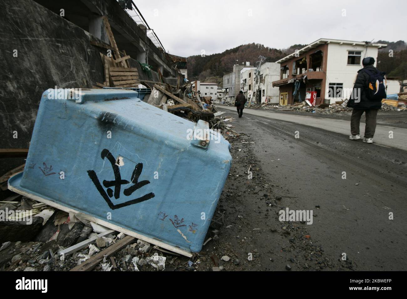 25 marzo 2011-Kamaishi, sopravvissuti nativi del Giappone che lasciano la loro casa su detriti e fango coperti a Tsunami ha distrutto la città della miniera a Kamaishi il 25 marzo 2011, Giappone. Il 11 marzo 2011, un terremoto ha colpito il Giappone con una magnitudo di 9,0, il più grande della storia registrata della nazione e uno dei cinque più potenti mai registrati in tutto il mondo. Nel giro di un'ora dal terremoto, le città che costeggiavano la riva sono state appiattite da un massiccio tsunami, causato dall'energia liberata dal terremoto. Con onde alte fino a quattro o cinque metri, si sono schiantati tra case civili, città e campi. (Phot Foto Stock