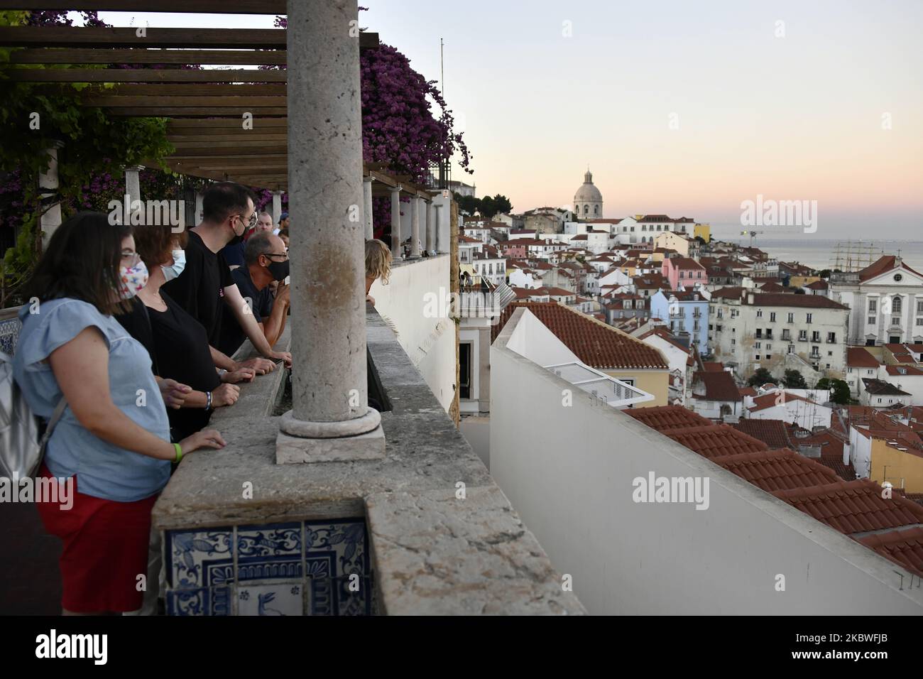 I turisti che indossano maschere protettive guardano la città di Lisbona dal punto di vista di Santa Luzia, 30 luglio 2020. Con l'arrivo dell'estate il Portogallo riapre le sue porte al turismo. I voli al di fuori dell'Unione europea saranno ora consentiti, ma i passeggeri dovranno sostenere il test Covid-19. La misura è stata annunciata giovedì dal Ministro dell'Amministrazione interna Eduardo Cabrita. Secondo il bollettino della direzione generale della Salute, dall'inizio della pandemia, sono stati confermati 50.868 casi di infezione e 1.727 decessi.la regione di Lisbona e vale do Tejo è dove le larve Foto Stock