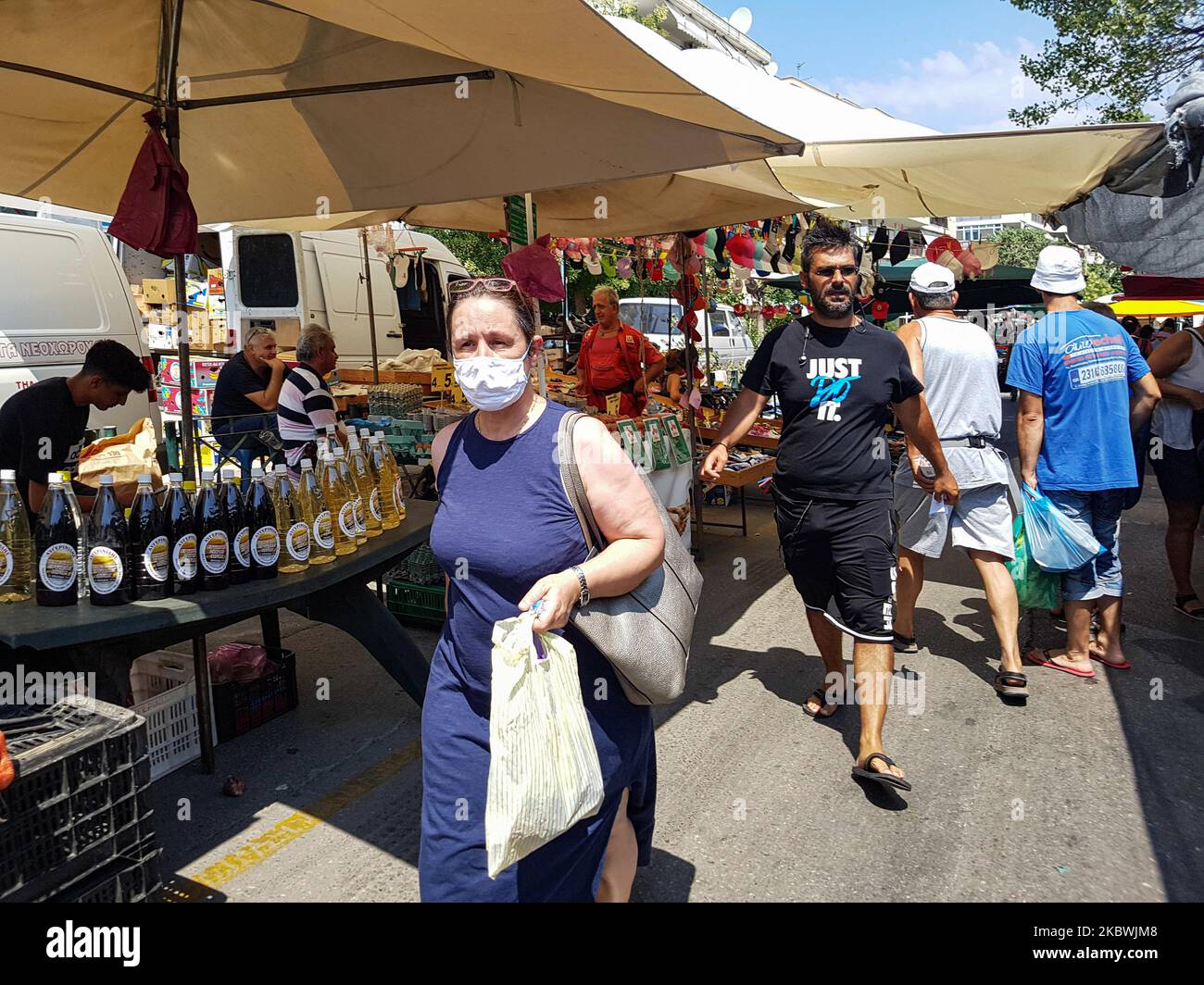 Una donna che indossa il facemask al mercatino delle pulci di Salonicco, Grecia, il 1 agosto 2020. Il pubblico greco ha iniziato a rilassarsi ed evitare l'obbligo di distensione sociale e di indossare le misure di sicurezza obbligatorie facemask a causa del Coronavirus Covid-19 epidemia pandemica durante uno dei giorni più caldi per l'estate, con la temperatura locale che raggiunge più di 40 gradi Celcius, un'ondata di caldo che forse darà il giorno più caldo dell'estate. La gente è vista in un mercato pubblico di strada senza una maschera di faccia, senza avere una distanza specifica e senza ogni venditore che ha soltanto un cliente come Foto Stock