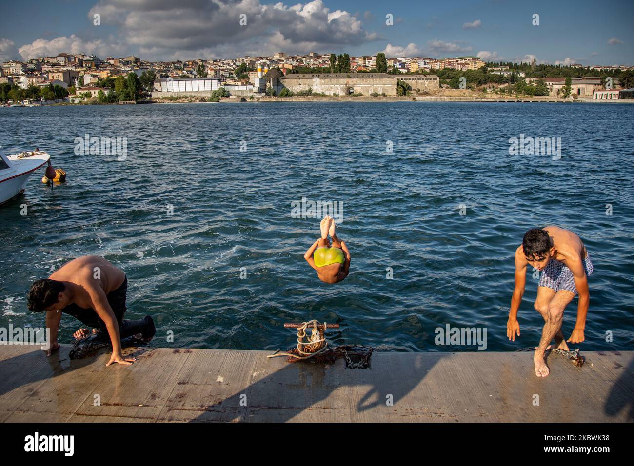 La gente salta nel Bosforo per rinfrescarsi mentre si gode il caldo durante il secondo giorno delle celebrazioni dell'Eid-al-Adha a Istanbul, Turchia, 01 agosto 2020. EID al-Adha è la più sacra delle due feste musulmane celebrate ogni anno, segna l'annuale pellegrinaggio musulmano (Hajj) per visitare la Mecca, il luogo più santo dell'Islam. I musulmani macellano un animale sacrificale e suddividono la carne in tre parti, una per la famiglia, una per gli amici e i parenti, e una per i poveri e i bisognosi. (Foto di Fayed El-Geziry/NurPhoto) Foto Stock