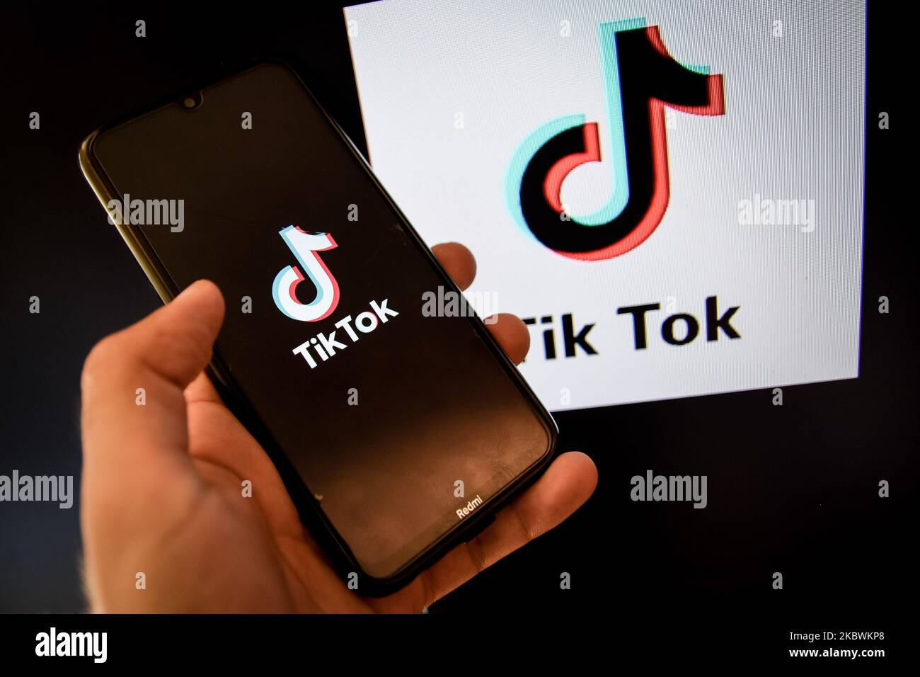 Logo TikTok closeup visualizzato sullo schermo di uno smartphone e un altro logo TikTok come sfondo su uno schermo TV a Chania, Isola di Creta, Grecia il 3 agosto 2020. Il presidente degli Stati Uniti Donald Trump sta minacciando e pianificando di vietare la popolare applicazione di condivisione video TikTok dagli Stati Uniti a causa del rischio per la sicurezza. (Foto di Nikolas Kokovlis/NurPhoto) Foto Stock