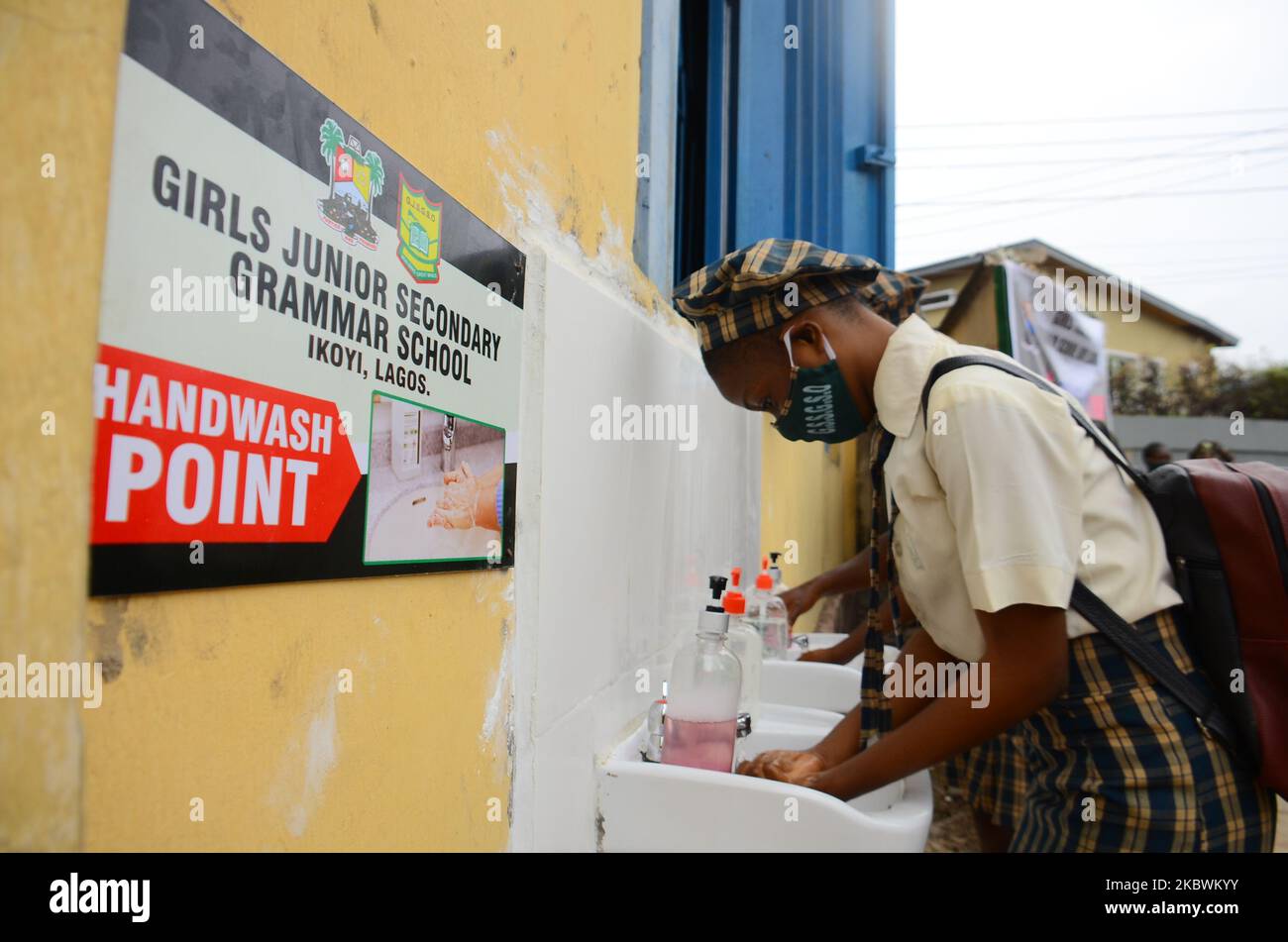 Gli studenti delle scuole superiori indossano la maschera facciale mentre si lavano le mani in un lavabo all'ingresso della Girls Junior Grammar School, S.W, Ikoyi, Lagos il 3 agosto 2020 il primo giorno dopo la ripresa delle lezioni dopo il blocco del coronavirus COVID-19. (Foto di Olukayode Jaiyeola/NurPhoto) Foto Stock