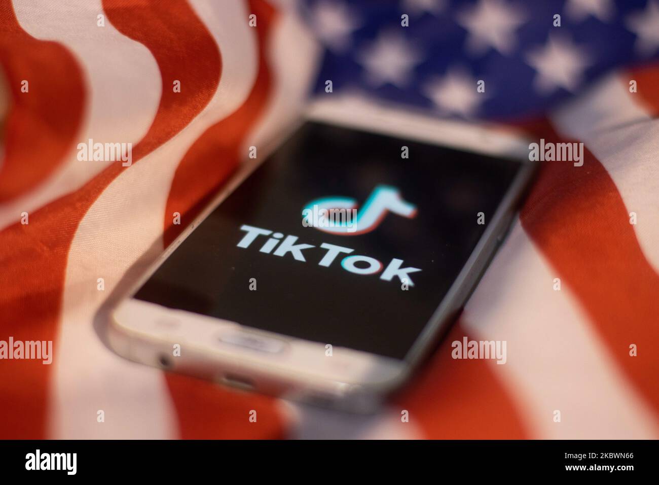 Logo TikTok closeup visualizzato su uno schermo del telefono, smartphone sulla bandiera americana o la bandiera degli Stati Uniti, la bandiera nazionale degli Stati Uniti sono visti in questa illustrazione di esposizione multipla. Tik Tok è un servizio di social networking cinese per la condivisione di video di proprietà di una società di tecnologie Internet con sede a Pechino, ByteDance. Viene utilizzato per creare brevi video di danza, sincronizzazione delle labbra, commedia e talenti. ByteDance ha lanciato l'app TikTok per iOS e Android nel 2017 e prima nel settembre 2016 Douyin fror il mercato in Cina. TikTok è diventata l'applicazione più scaricata negli Stati Uniti nell'ottobre 2018. Presidente degli Stati Uniti Donald Trump i Foto Stock
