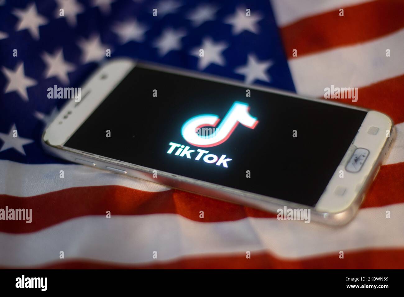 Logo TikTok closeup visualizzato su uno schermo del telefono, smartphone sulla bandiera americana o la bandiera degli Stati Uniti, la bandiera nazionale degli Stati Uniti sono visti in questa illustrazione di esposizione multipla. Tik Tok è un servizio di social networking cinese per la condivisione di video di proprietà di una società di tecnologie Internet con sede a Pechino, ByteDance. Viene utilizzato per creare brevi video di danza, sincronizzazione delle labbra, commedia e talenti. ByteDance ha lanciato l'app TikTok per iOS e Android nel 2017 e prima nel settembre 2016 Douyin fror il mercato in Cina. TikTok è diventata l'applicazione più scaricata negli Stati Uniti nell'ottobre 2018. Presidente degli Stati Uniti Donald Trump i Foto Stock