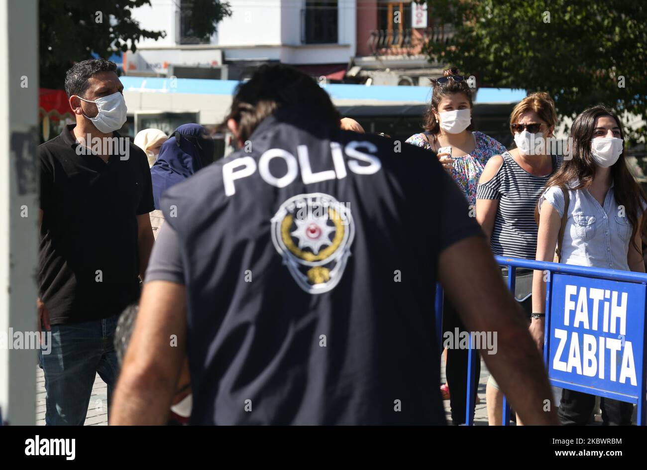 La gente attende la preghiera di mezzogiorno mentre la polizia turca si accaura la zona di fronte alla Moschea di Hagia Sophia a Istanbul, Turchia, 5 agosto 2020. Hagia Sophia è stata ufficialmente aperta come moschea il 24 luglio. (Foto di Sayed Najafizada/NurPhoto) Foto Stock