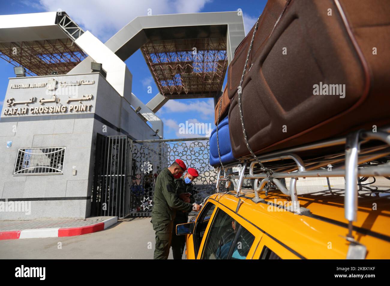 Gli agenti di sicurezza di Hamas controllano l'elenco dei passeggeri in attesa al cancello per attraversare il confine con il lato egiziano del passaggio di Rafah, a Rafah, striscia di Gaza, martedì 11 agosto, 2020. L'Egitto ha riaperto Rafah Crossing per tre giorni a partire da martedì per i casi umanitari dentro e fuori dalla striscia di Gaza, compresi i pazienti medici e le persone che avevano la cittadinanza egiziana e internazionale. Il confine è stato chiuso da marzo. (Foto di Majdi Fathi/NurPhoto) Foto Stock