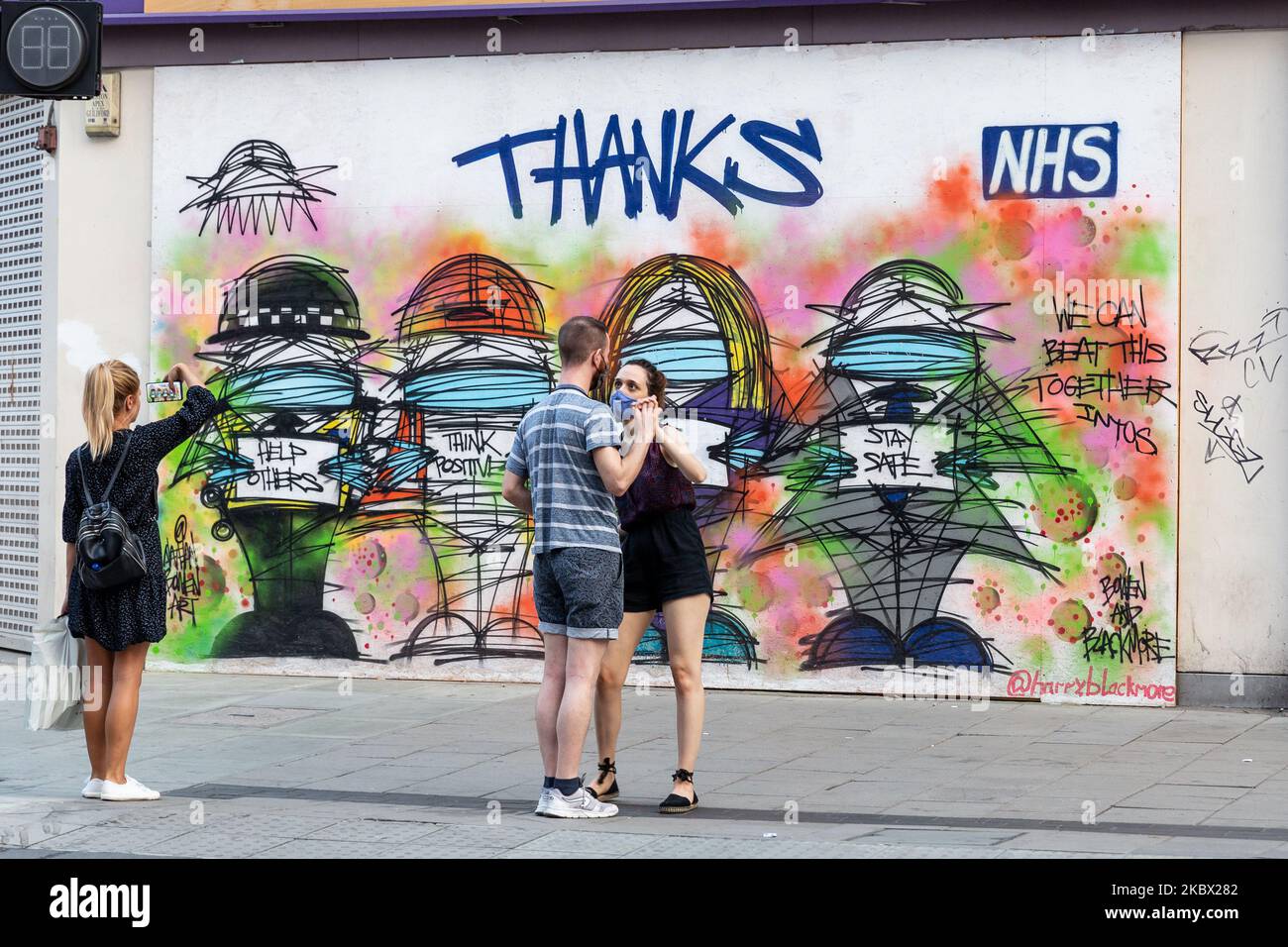 Una coppia in maschere protettive è visto ballare di fronte ai graffiti a tema Coronavirus a Oxford Street, come Coronavirus Lockdown facilita a Londra, Inghilterra, United Kingdomon, 11 agosto 2020. Lockdown ha costretto molti rivenditori a limitare le operazioni dei suoi negozi di alta strada. (Foto di Dominika Zarzycka/NurPhoto) Foto Stock