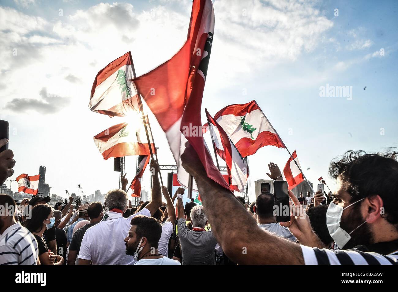 La gente sventola bandiere libanesi a una protesta nei pressi del porto, il 11 agosto 2020 a Beirut, in Libano. L'esplosione della scorsa settimana, che ha ucciso più di 200 persone e ha ferito migliaia di altre persone, è vista da molti libanesi come una manifestazione mortale di malpratiche governative. (Foto di Str/NurPhoto) Foto Stock