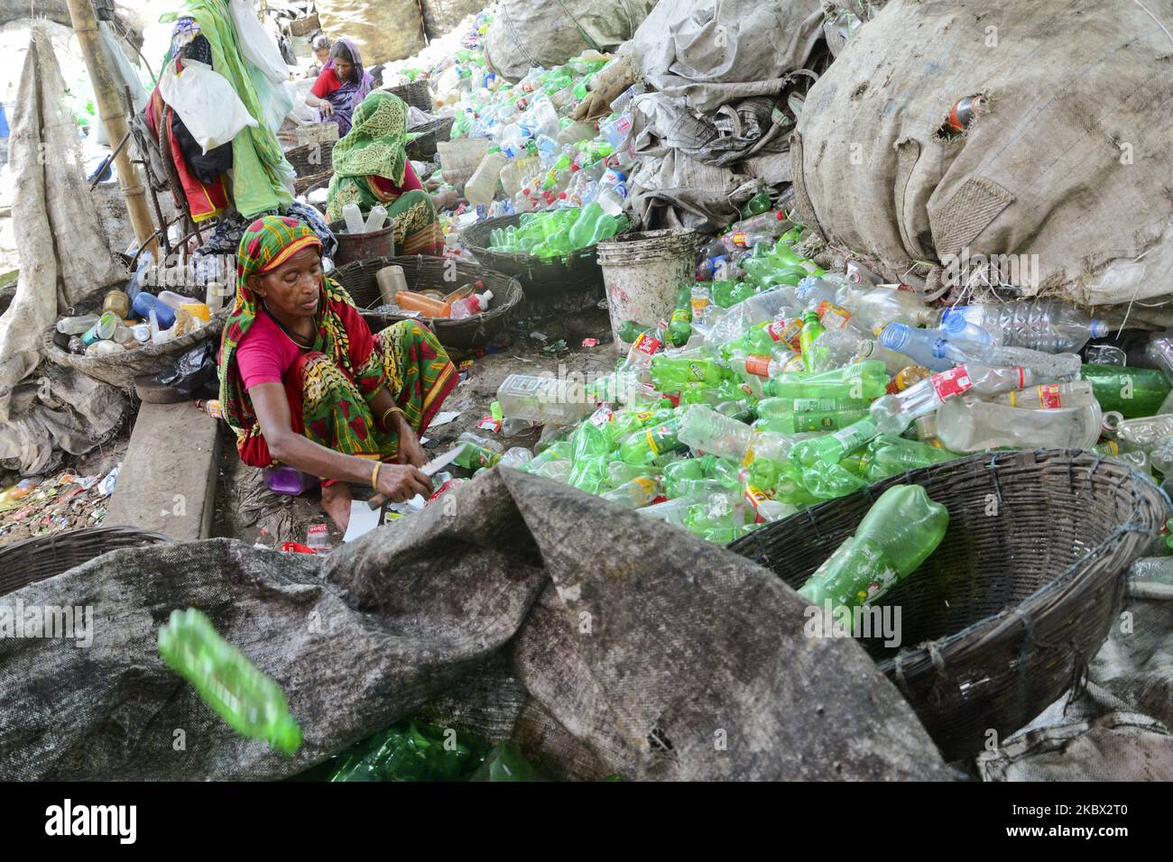 Le lavoratrici della donna ordinano le bottiglie di polietilentereftalato (PET) in una fabbrica di riciclaggio a Dhaka, Bangladesh, il 12 agosto 2020. Negli ultimi due anni il riciclaggio delle bottiglie di plastica è diventato un'attività in crescita e contribuisce alla tutela dell'ambiente. Secondo la BPFMEA (Bangladesh PET Flakes Manufacturers and Exporters Association), il Bangladesh esporta in media circa 30.000 tonnellate di scaglie di PET in bottiglia principalmente verso Cina, Corea del Sud e Taiwan per un valore di $14 milioni di dollari l'anno. (Foto di Mamunur Rashid/NurPhoto) Foto Stock