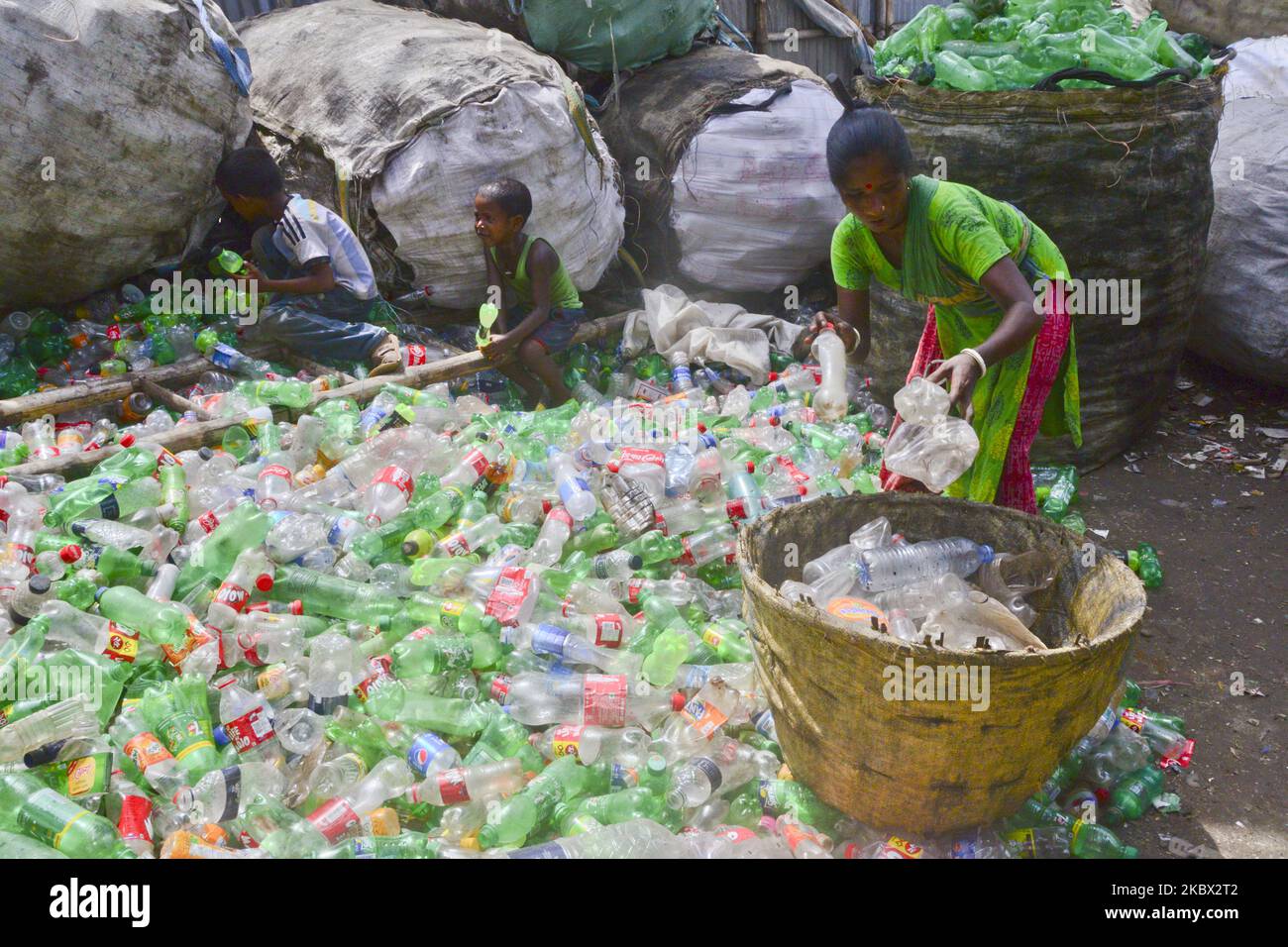 Le lavoratrici della donna ordinano le bottiglie di polietilentereftalato (PET) in una fabbrica di riciclaggio a Dhaka, Bangladesh, il 12 agosto 2020. Negli ultimi due anni il riciclaggio delle bottiglie di plastica è diventato un'attività in crescita e contribuisce alla tutela dell'ambiente. Secondo la BPFMEA (Bangladesh PET Flakes Manufacturers and Exporters Association), il Bangladesh esporta in media circa 30.000 tonnellate di scaglie di PET in bottiglia principalmente verso Cina, Corea del Sud e Taiwan per un valore di $14 milioni di dollari l'anno. (Foto di Mamunur Rashid/NurPhoto) Foto Stock