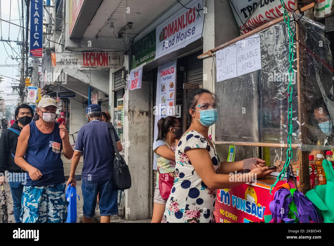 Le persone qualificate a Antipolo City, Filippine, il 15 agosto 2020 sono in attesa in coda per ricevere un sussidio in contanti davanti al negozio che si trasforma in una struttura per transazioni SAP. (Foto di Ryan Eduard Benaid/NurPhoto) Foto Stock