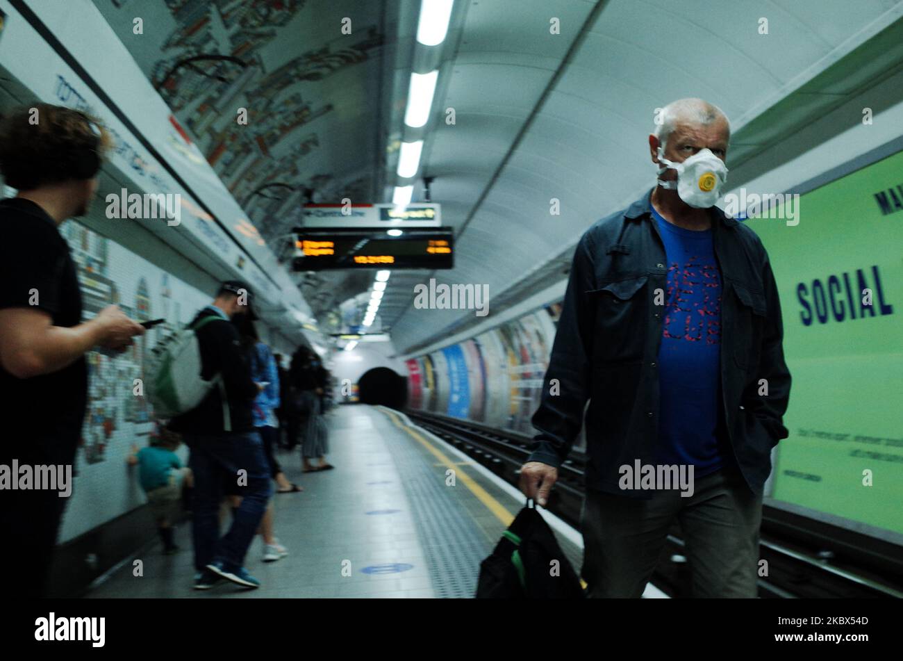 Un uomo che indossa una maschera facciale, attualmente imposto sui trasporti pubblici, cammina lungo una piattaforma della Northern line alla stazione di Tottenham Court Road a Londra, Inghilterra, il 14 agosto 2020. Il numero di passeggeri della metropolitana di Londra rimane ben al di sotto dei livelli pre-pandemici, mentre la città continua la sua esitazione dal blocco del coronavirus, con i timori del covid-19 che ancora oggi molti non utilizzano i trasporti pubblici. (Foto di David Cliff/NurPhoto) Foto Stock
