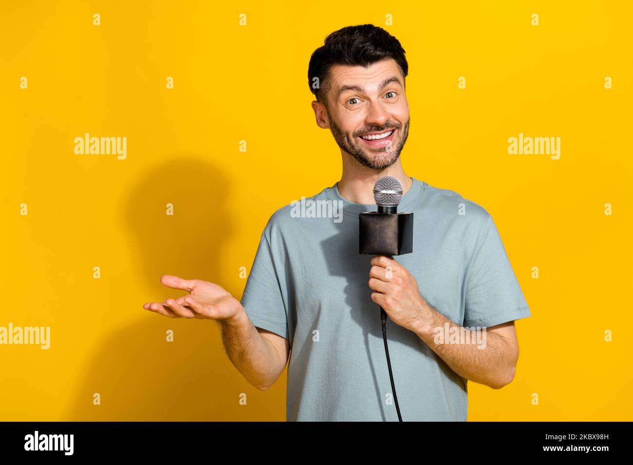 Foto di un uomo di talento positivo annunciatore parlare microfono raccontare rompere vere notizie spazio vuoto isolato su sfondo giallo colore Foto Stock