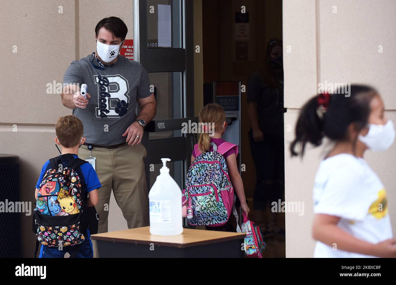 Il preside Nathan Hay controlla le temperature degli studenti quando tornano a scuola il primo giorno delle lezioni di persona nella contea di Orange presso la scuola elementare Baldwin Park il 21 agosto 2020 a Orlando, Florida, Stati Uniti. Maschere facciali e controlli della temperatura sono necessari per tutti gli studenti, dato che il bilancio delle morti della Florida dal COVID-19 supera ora i 10.000, con alcuni insegnanti che rifiutano di tornare in classe a causa di problemi di salute. (Foto di Paul Hennessy/NurPhoto) Foto Stock