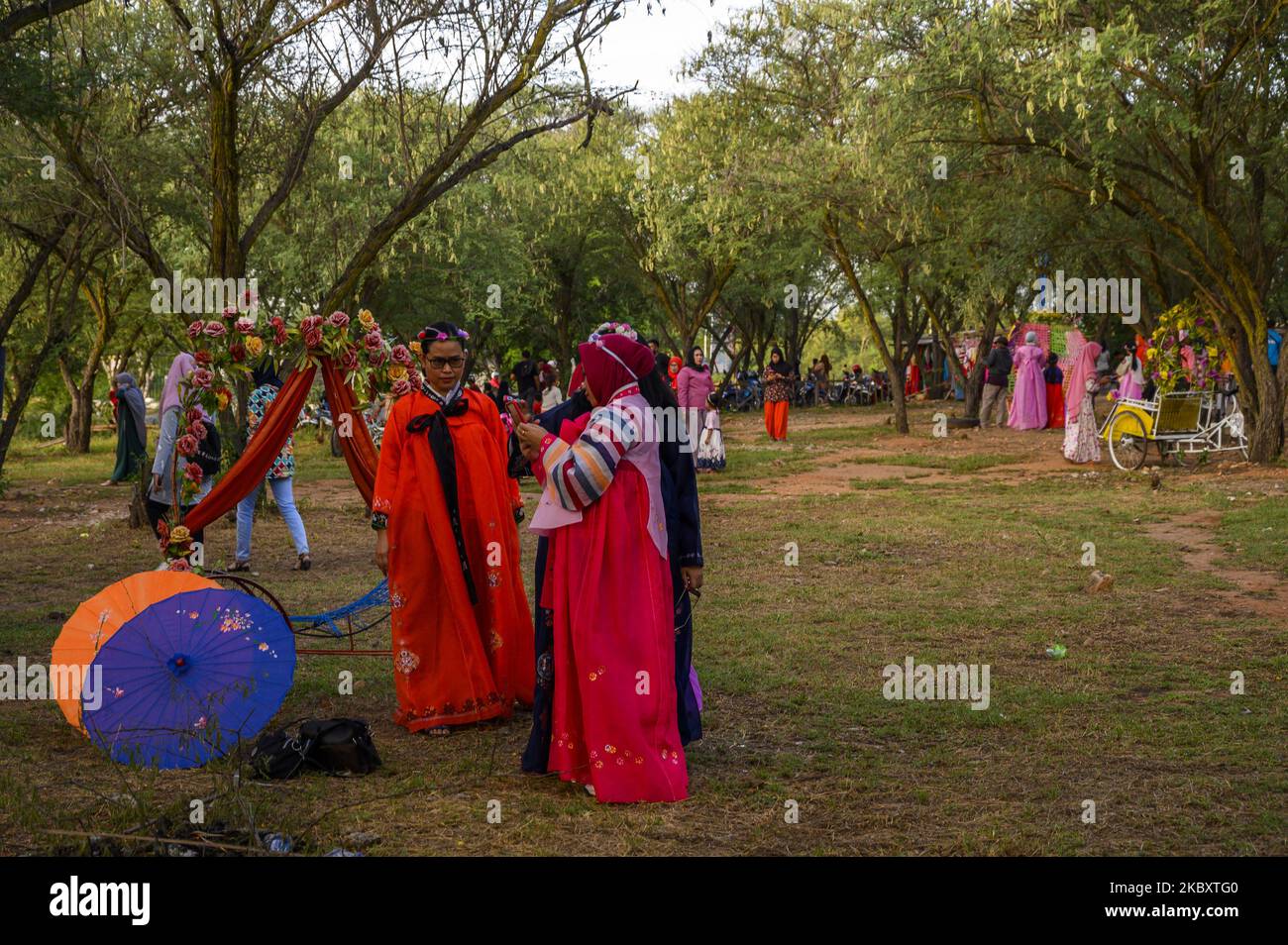 Turisti che indossano abiti tradizionali coreani (Hanbok) noleggiati da un servizio di noleggio costumi per scattare foto in una località turistica naturale a Palu City, nella provincia di Sulawesi Centrale, Indonesia il 30 agosto 2020. Dopo che il governo locale ha rilassato le sue politiche di restrizione sociale e riaperto le aree ricreative, i turisti erano impegnati a visitare di nuovo. La politica di allentamento si basa sul numero decrescente di malati di COVID-19 e sul numero crescente di malati che vengono dichiarati nuovamente curati. Nella Provincia di Sulawesi Centrale, il numero accumulato di malati di COVID-19 era di 241 persone, 219 delle quali erano d Foto Stock