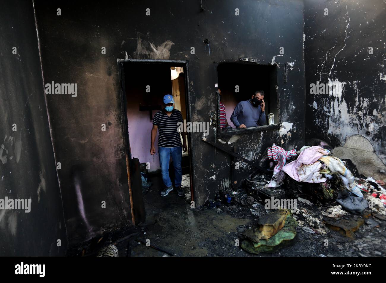 I palestinesi controllano una casa che è stata in fiamme prendendo la vita di tre bambini dopo che un incendio è stato acceso da una candela usata per illuminare la loro stanza durante un'interruzione di corrente nel campo profughi di al-Nusirat nella striscia centrale di Gaza il 2 settembre 2020. - In risposta ai continui lanci di palloncini d'arson dalla striscia di Gaza, Israele ha vietato la pesca al largo delle coste di Gaza e ha chiuso l'attraversamento delle merci Kerem Shalom, interrompendo le forniture di carburante all'unica centrale elettrica del territorio. L'alimentazione era in corto anche prima dello spegnimento, con i consumatori che hanno accesso alla rete elettrica solo per circa otto ora Foto Stock