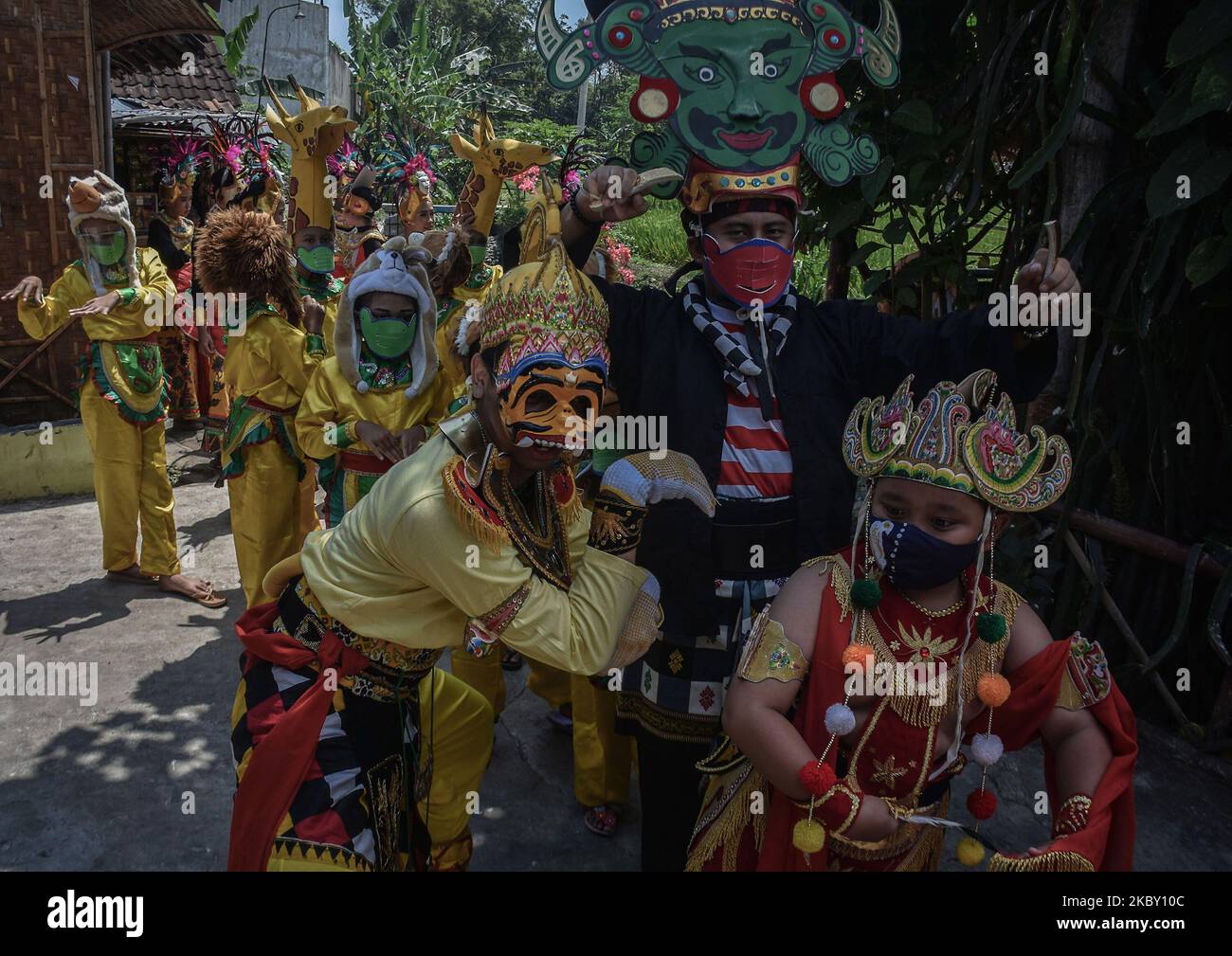 I partecipanti al rituale vestito come Anoman (una figura di scimmia nella storia di Mahabarata) e i bambini vestiti come animali, si dirigono verso l'area della tomba del creatore dell'arte della maschera di Malangan (Mbah reni) nel villaggio di Polowijen, Malang, Giava Orientale, Indonesia, il 29 agosto, 2020. La tradizione del pellegrinaggio e della santificazione con la preghiera 'Mask Art Malangan' che si svolge una volta all'anno. Questo può essere effettuato dopo aver agevolato le attività del governo locale durante l'epidemia di Covid-19 verso una nuova normalità. (Foto di Aman Rochman/NurPhoto) Foto Stock