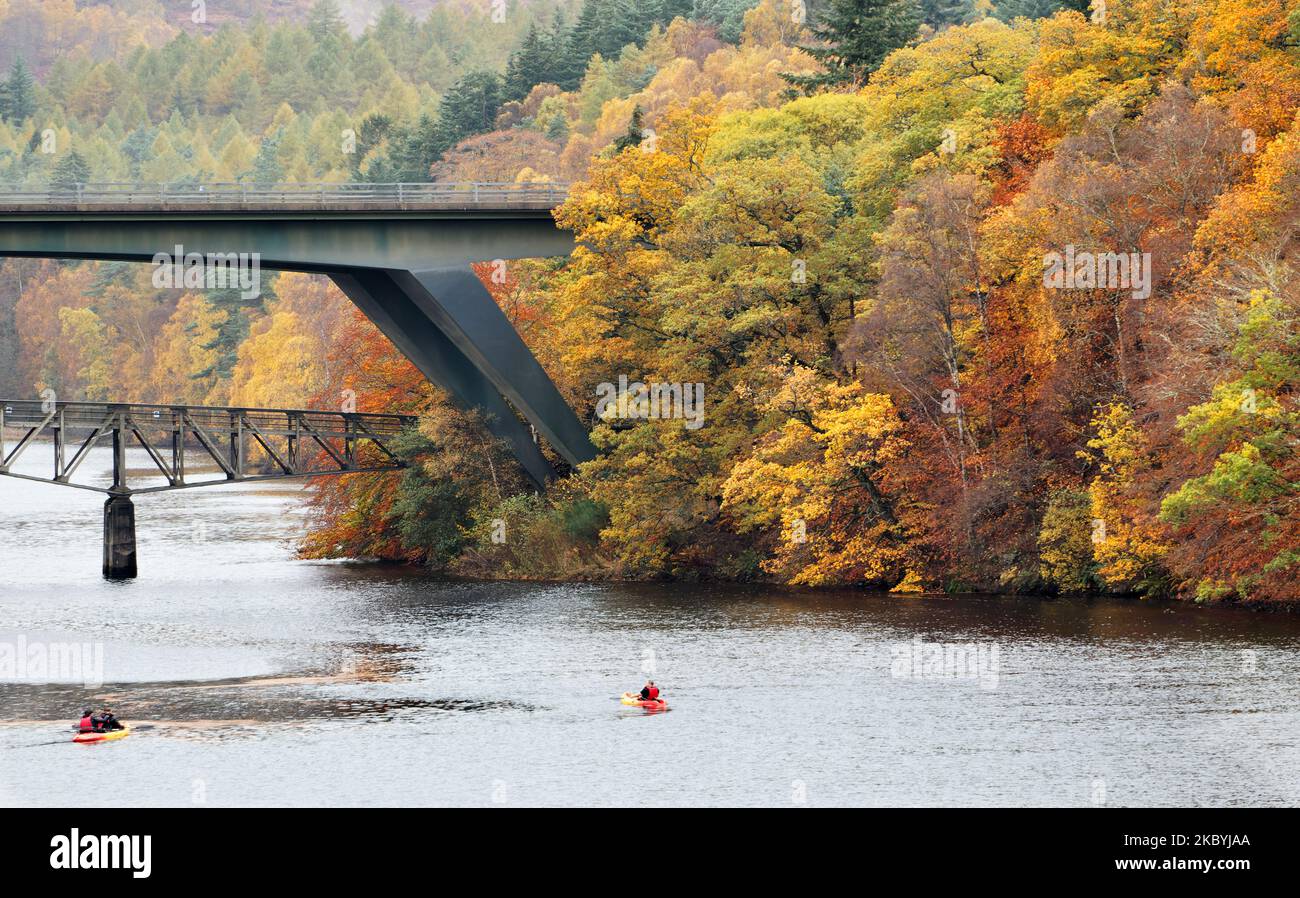 Pitlochry Perthshire Scotland Loch Faskally due kayak sotto il ponte stradale A9 e Clunie ponte a piedi gli alberi in colori autunnali Foto Stock