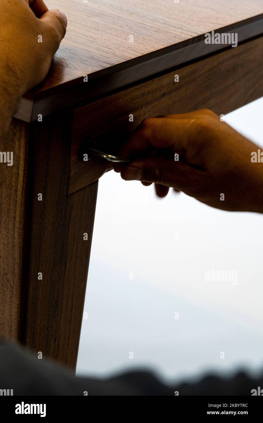 arredamento, concetto di casa e di movimento, primo piano di mani maschili assemblare mobili per la casa. disassemblato design mobili messico Foto Stock