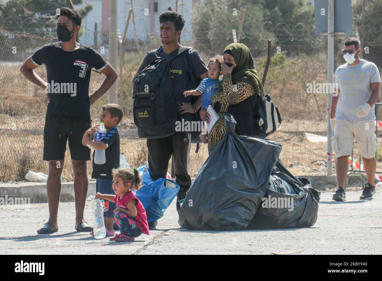 Le famiglie di migranti provenienti dall'Afghanistan sono viste in attesa in fila, si registrano, hanno un test rapido Coronavirus Covid-19 ed entrano nel nuovo campo profughi dell'isola di Lesbos, Grecia dopo il grande incendio che ha distrutto completamente il campo di Moria, prima accoglienza e registrazione campo profughi sull'isola. Il nuovo campo vicino alla capitale dell'isola Mytilene a Mavrovouni o Kara Tepe è un ex campo di tiro militare pratica, ma i migranti sono scettici di entrare in quanto è una struttura chiusa per il momento che non permetterà loro di vagare liberamente, nonostante il fatto che il cibo, tende, servizi igienici e m Foto Stock